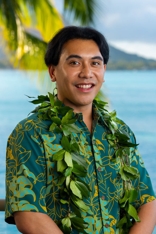 Man wearing a fresh Big Island Hilo-style maile lei with Diamond Head, a palm tree, and the ocean in the background.