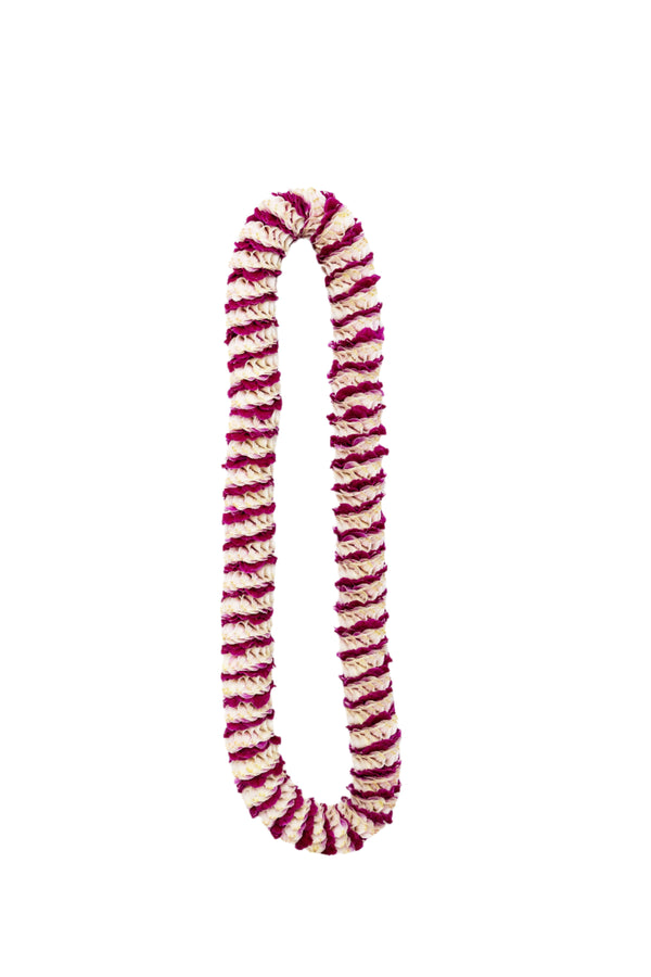 Purple premium spiral orchid lei featuring an intricate pattern with small sections of purple petals alternating with larger sections of the light-colored backing of orchid blossoms.