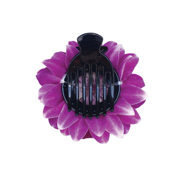 Black hair comb on a purple orchid petal flower with a white background.
