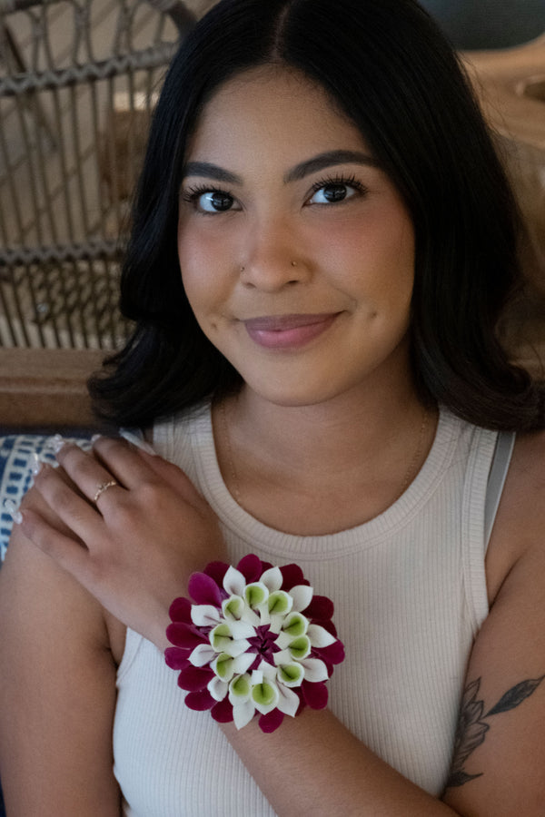 Colorful floral orchid wristlet worn on the hand of a girl.