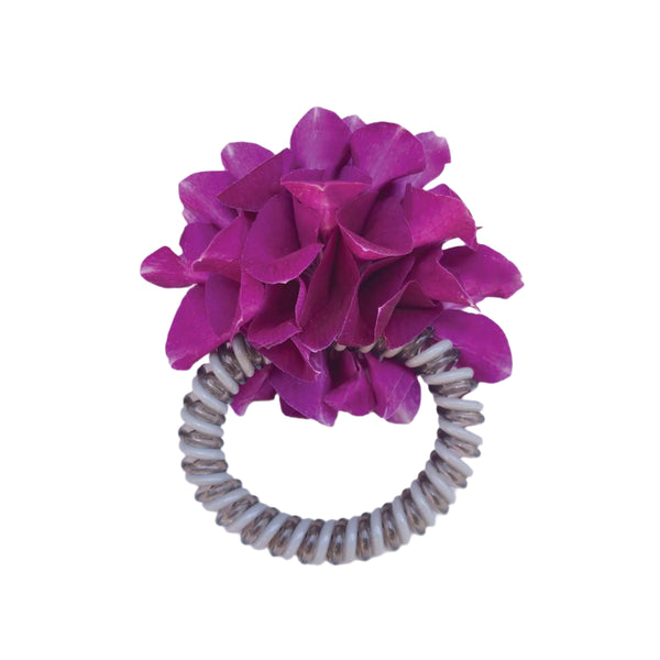 Hair tie with purple orchid petals on a white background.