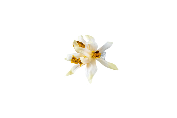 Hair clip featuring three faux white orchids with yellow centers.