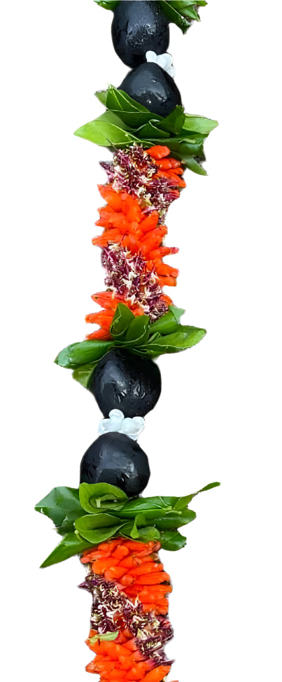 Close-up of a lei featuring cigar flowers in varying shades, interwoven with green ti leaves, glossy black Kukui nuts, and white Mongo shells, highlighting the texture and natural contrast.