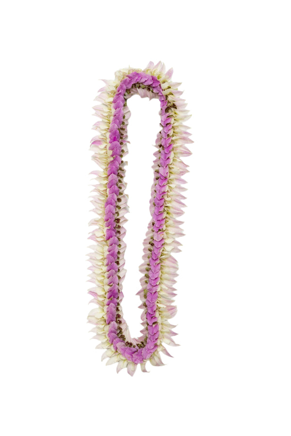A flat orchid lei made with pastel pink petals on the edges, deeper pink blossoms, and a hint of jade green in the center, laid out on a white surface.