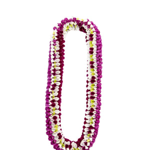 Colorful lei made of orchid petals combining purple, white, and jade green hues in a vibrant arrangement.