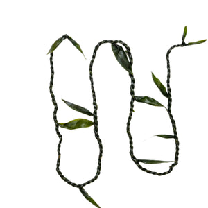 Single ti leaf lei twisted like a rope, with extra leaves protruding at intervals along the length.