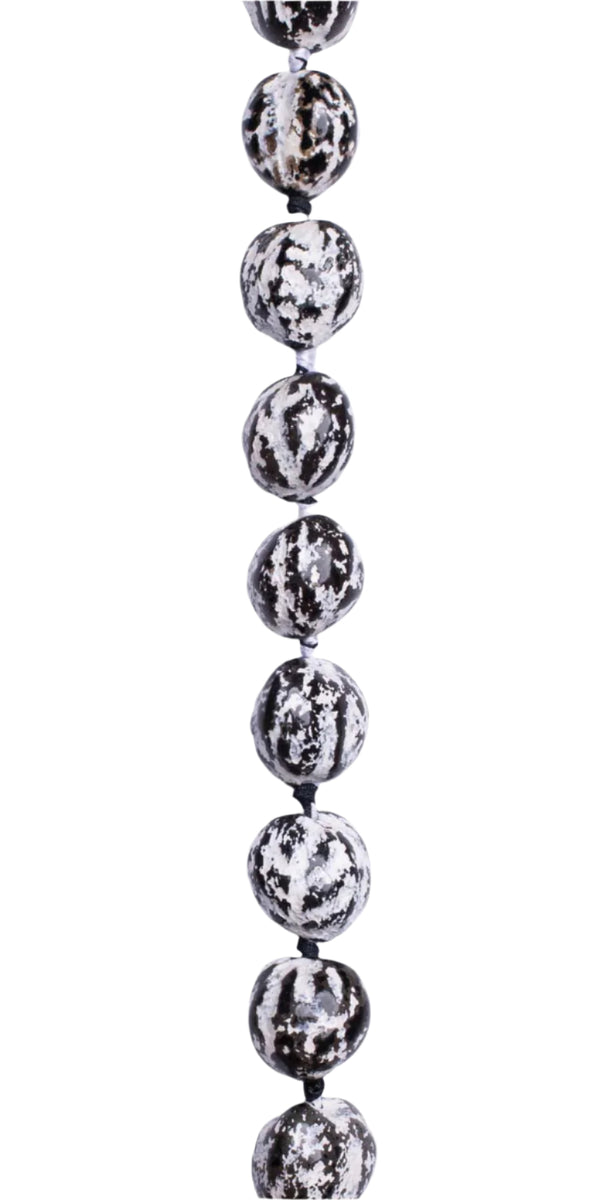 Lei close-up showing polished black and white kukui nuts with a smooth, glossy finish.